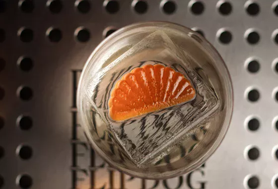 Cedroni cocktail with a large ice cube and orange garnish